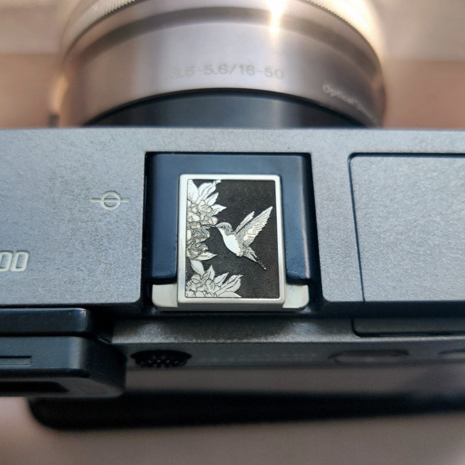 Silver brass hot shoe cover engraved with hummingbird design – for Fujifilm and Leica cameras
