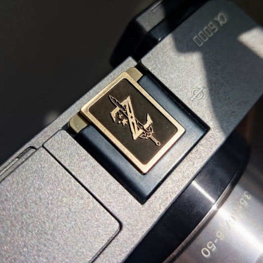 brass camera hot shoe cap with symbolic design
