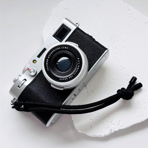 Vintage camera with a strap on a white background