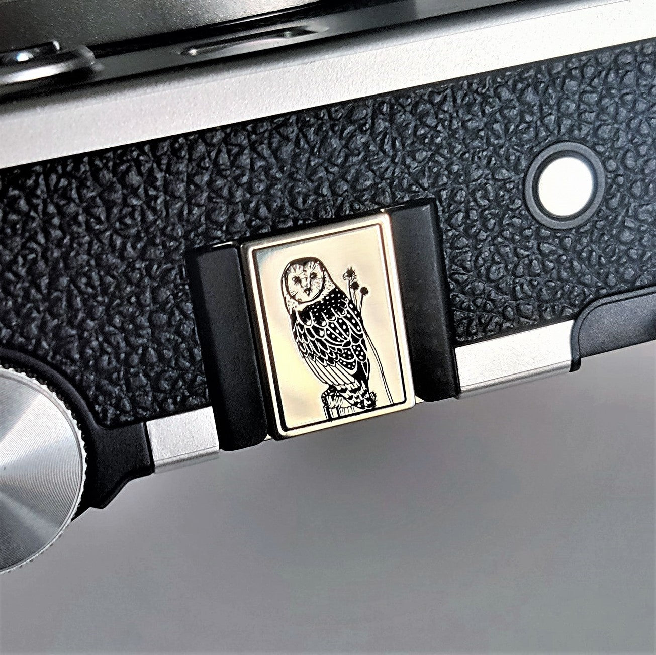 Owl brass hot shoe cover installed on Fujifilm mirrorless camera
