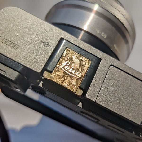 vintage brass hot shoe accessory with red Leica logo