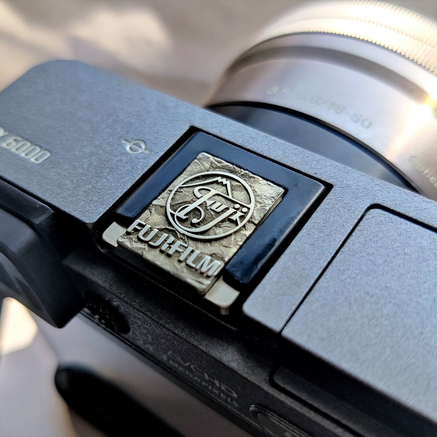 Greypeak silver hot shoe cover mounted on Fujifilm X100 camera