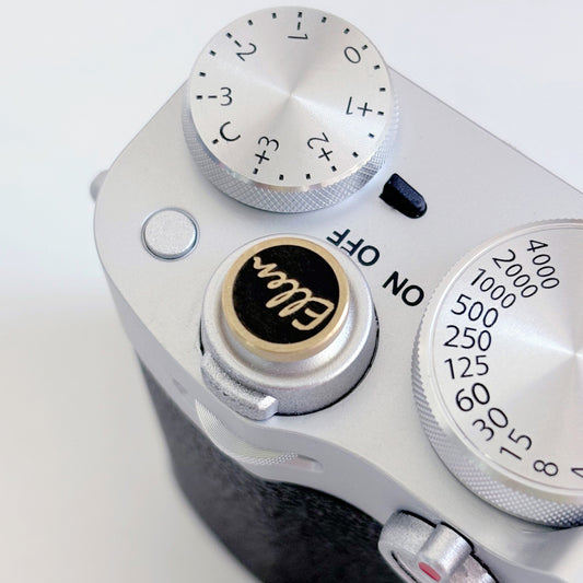 gold soft release button with name "ellen" engraved on fuji camera