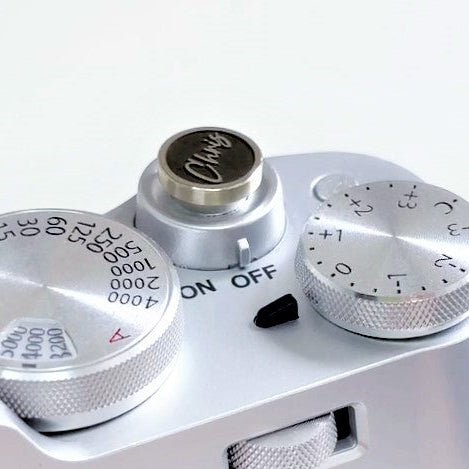 Close-up sideview of a custom camera shutter button on a white background