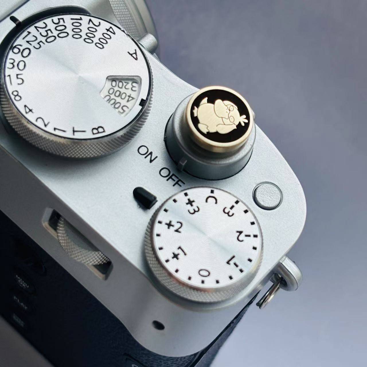 Close-up of a camera's shutter button with Psyduck engraved