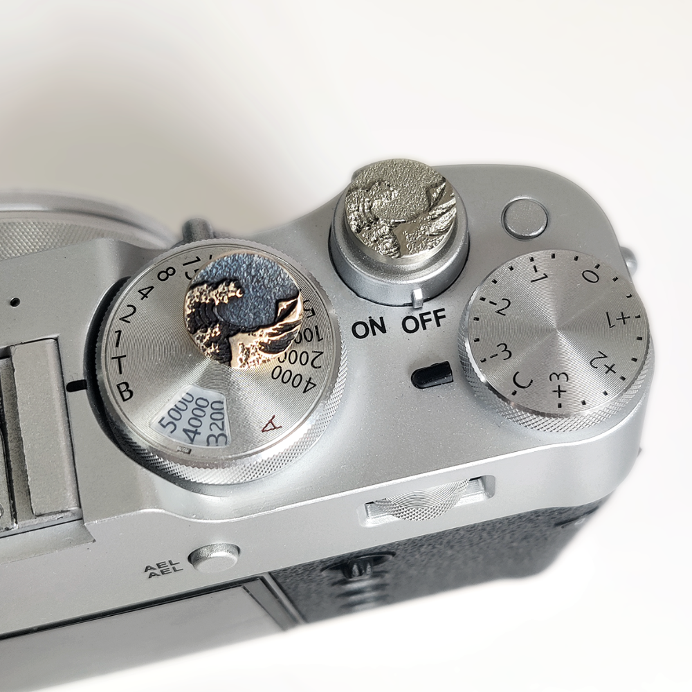 metal camera shutter button with ocean wave design