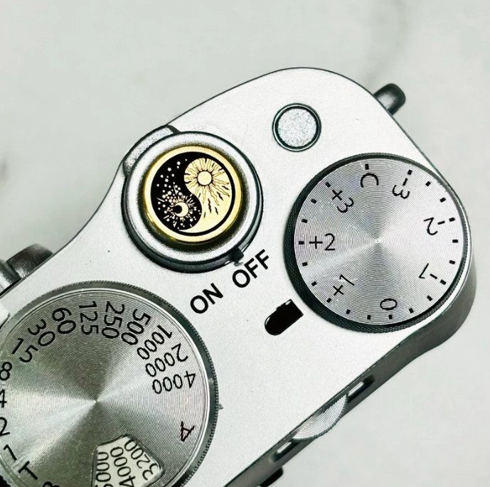 brass or copper camera accessory with celestial motif