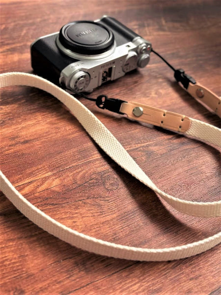 white canvas top leather camera neck strap on fuji camera