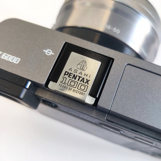 Pentax hot shoe cover installed on camera - silver metal design