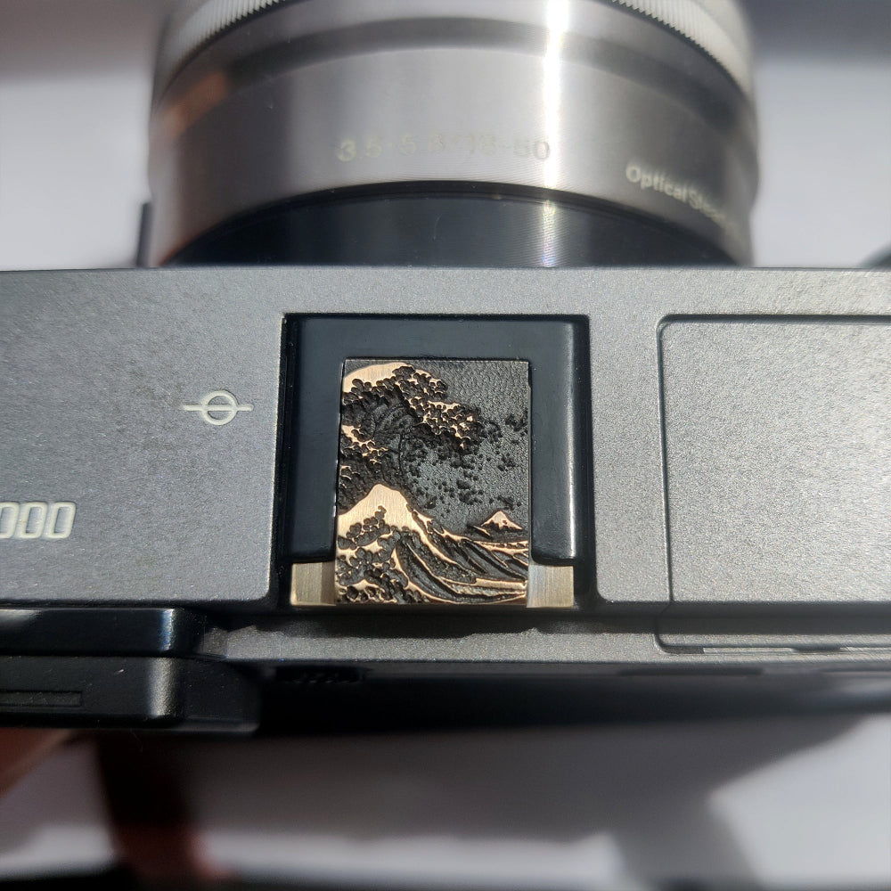 Gold ocean wave camera hot shoe cover mounted on Fujifilm X100