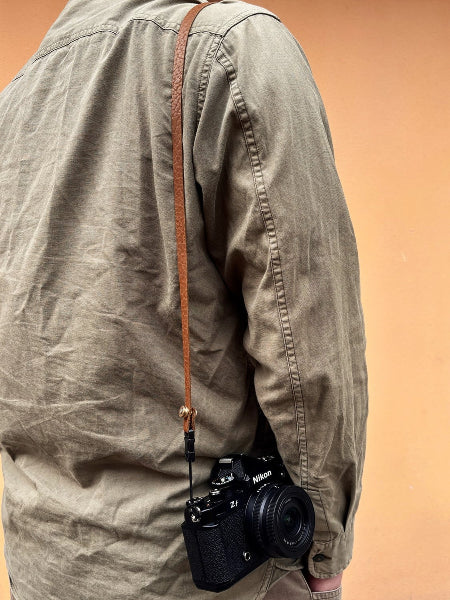 bison embossed leather texture camera strap on the shoulder
