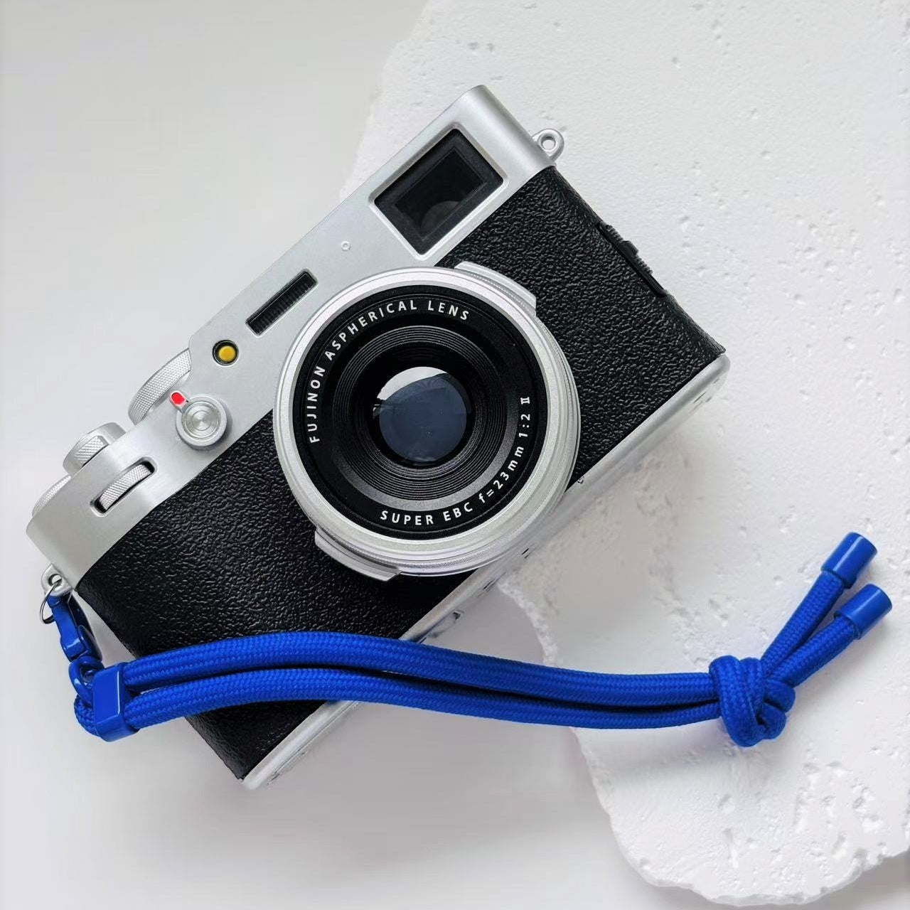 Vintage camera with a blue strap on a white surface