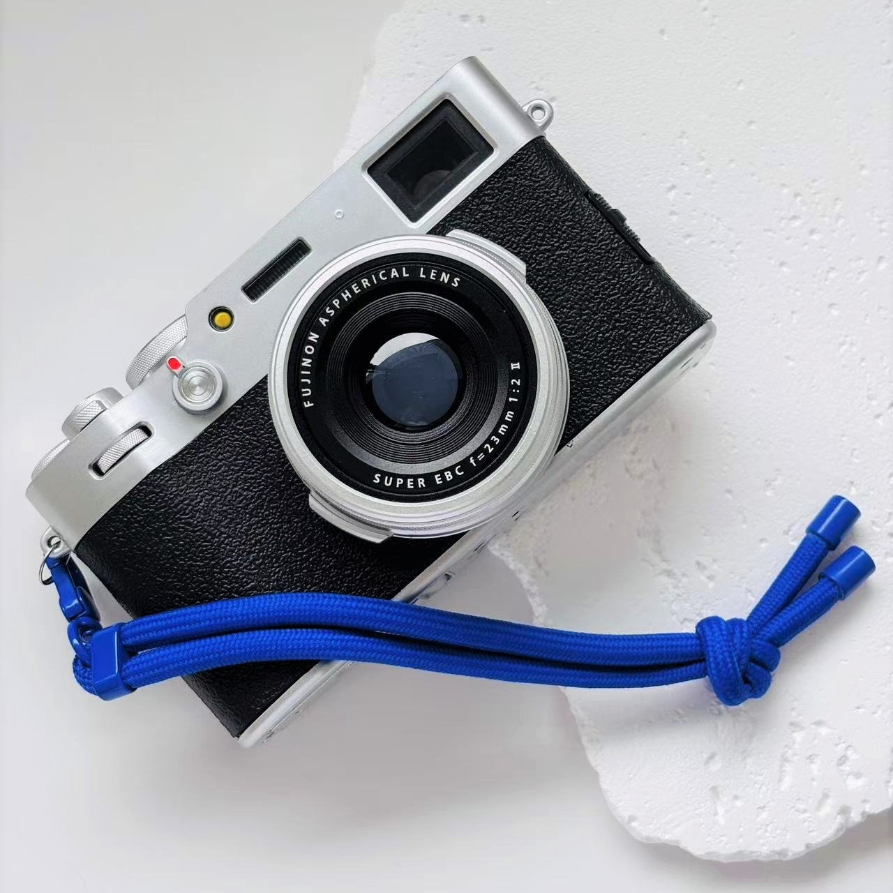 Vintage camera with a blue strap on a white surface