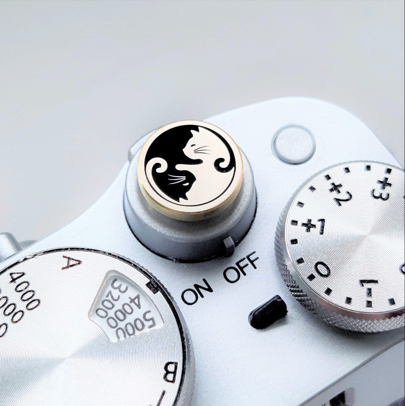 brass camera shutter button with cat design installed on camera