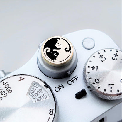 brass camera shutter button with cat design installed on camera