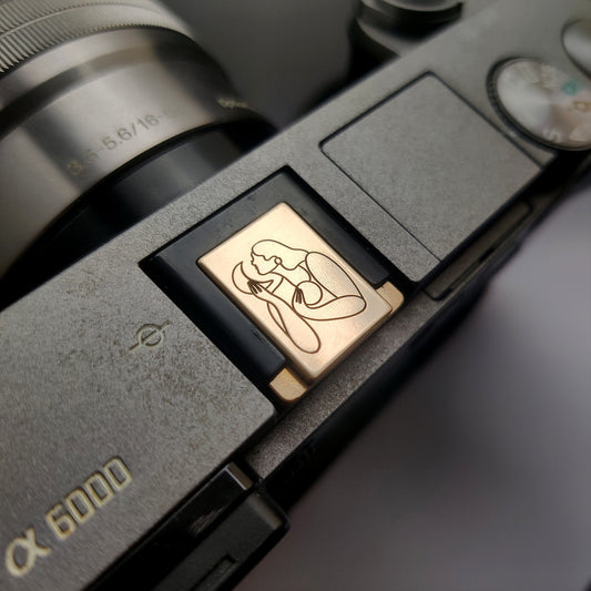 gold hot shoe cover engraved with Maggie Stephenson art on Sony camera