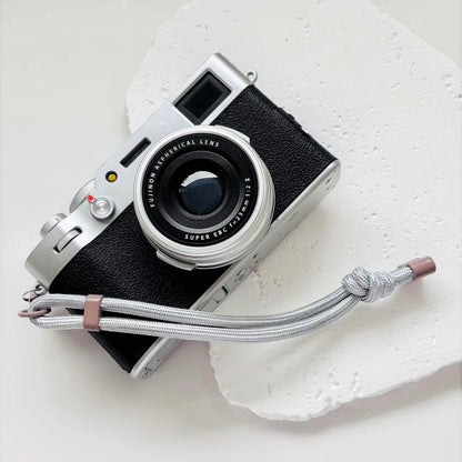 Vintage camera with a strap on a textured white surface