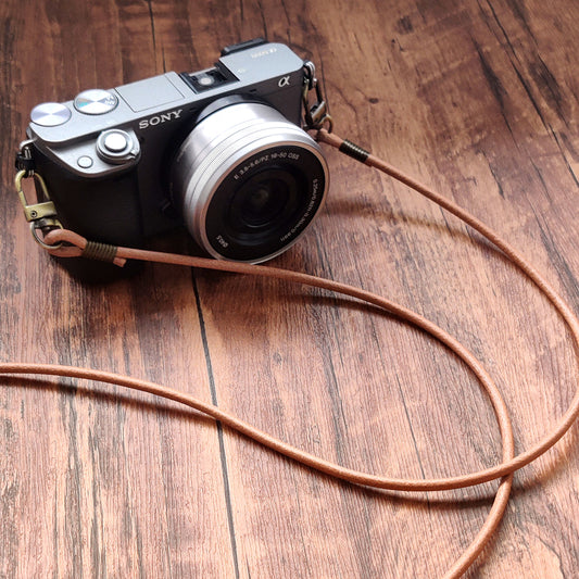 Sony camera with a leather strap on a wooden surface