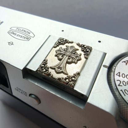 Close-up of a vintage camera with ornate design on the lens cover.