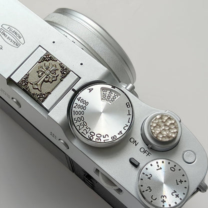 Close-up of a Canon camera with control dials on a light gray background