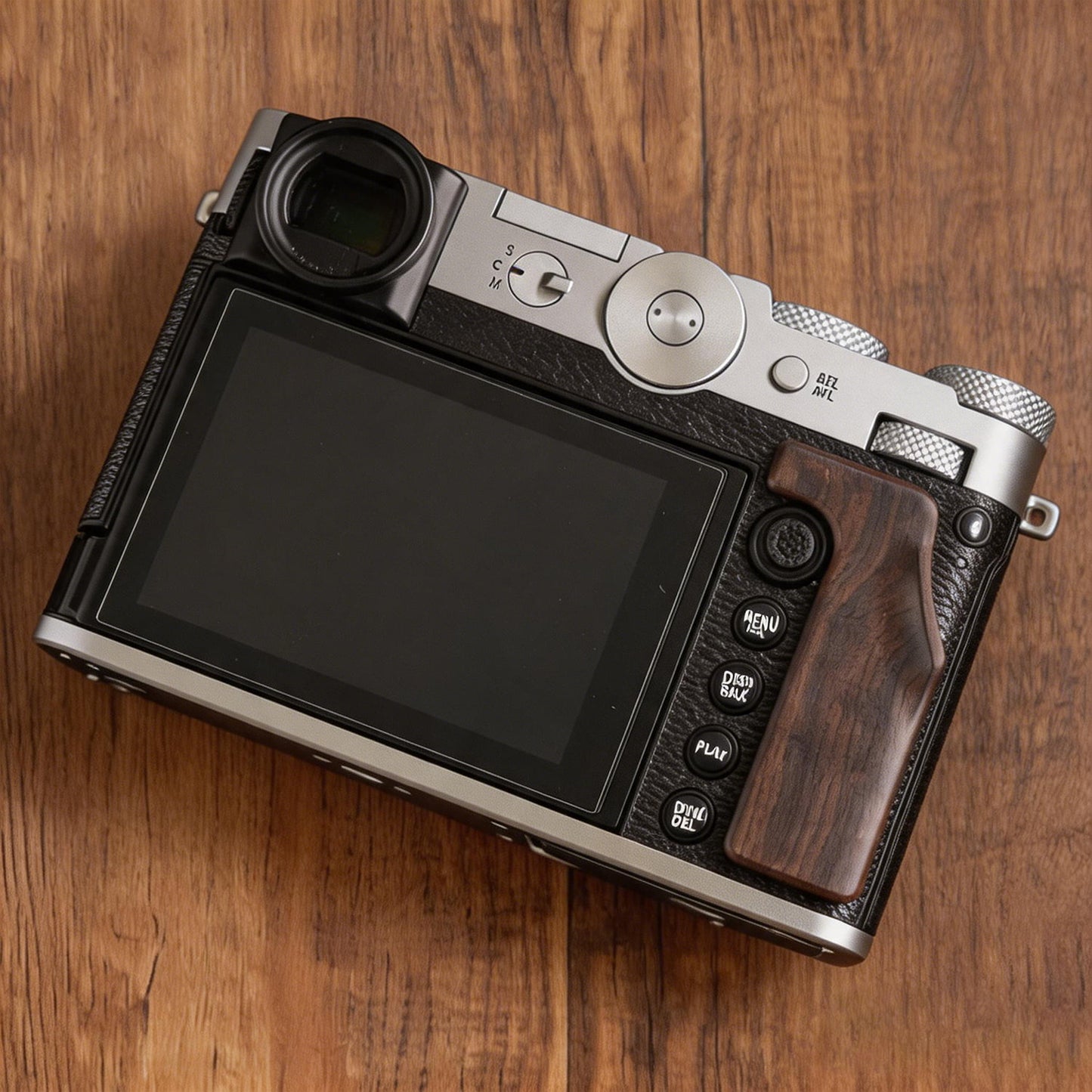 A Fuji GFX100RF camera with a textured black leather grip on a wooden surface.