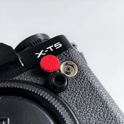 Close-up of black and red camera flash pc sync terminal cap cover
