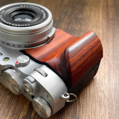 Close-up Fuji X100VI camera with red wood camera grip 