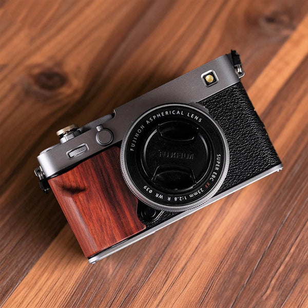 Fujifilm X-E5 camera with red wood grip on wood surface