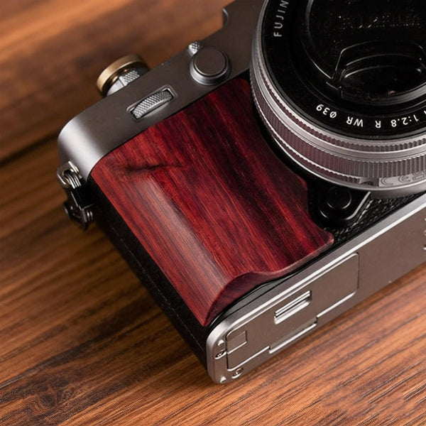Fujifilm X-E5 camera with red wooden grip on a wooden surface