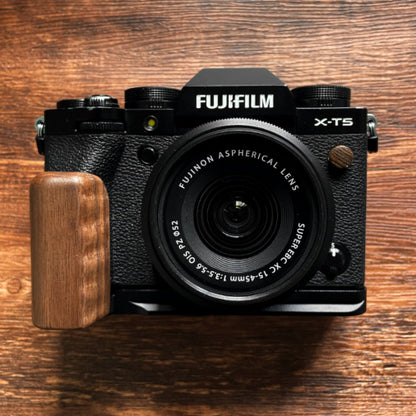 Fujifilm camera with a walnut wood L-shaped grip on a wooden surface