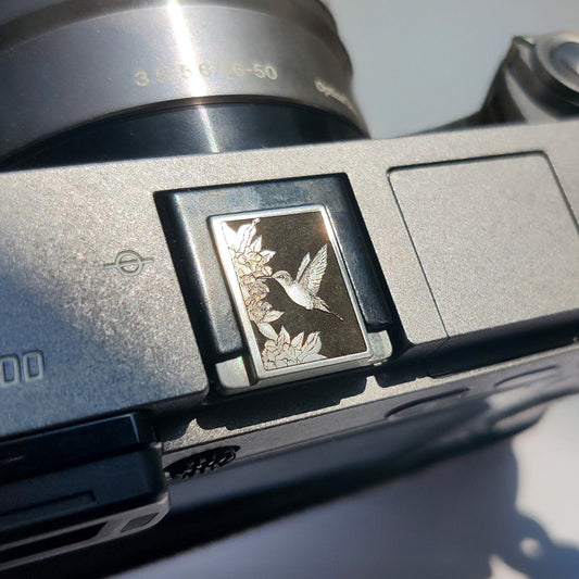 Minimalist camera accessory in brushed silver brass with bird motif