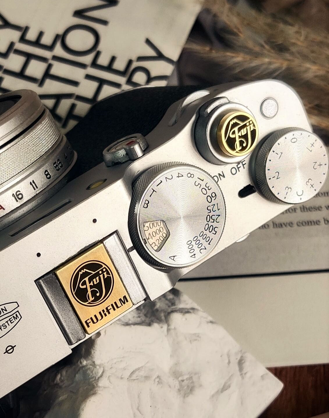 fujifilm x100vi camera with gold hot shoe cover and shutter release button bundle
