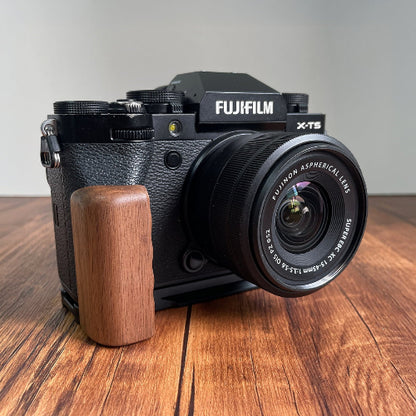 Fujifilm camera walnut wood L-shaped grip on a wooden surface
