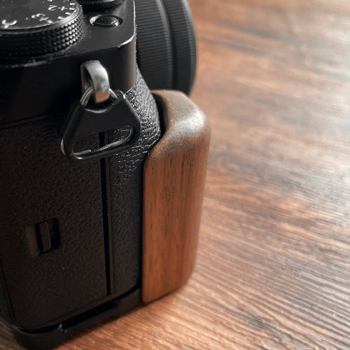 Fujifilm XT5 camera with wooden grip on a wooden surface