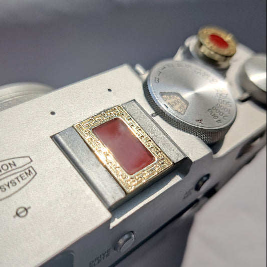 gold and gem hot shoe cover with shutter release button on fujifilm x100vi camera