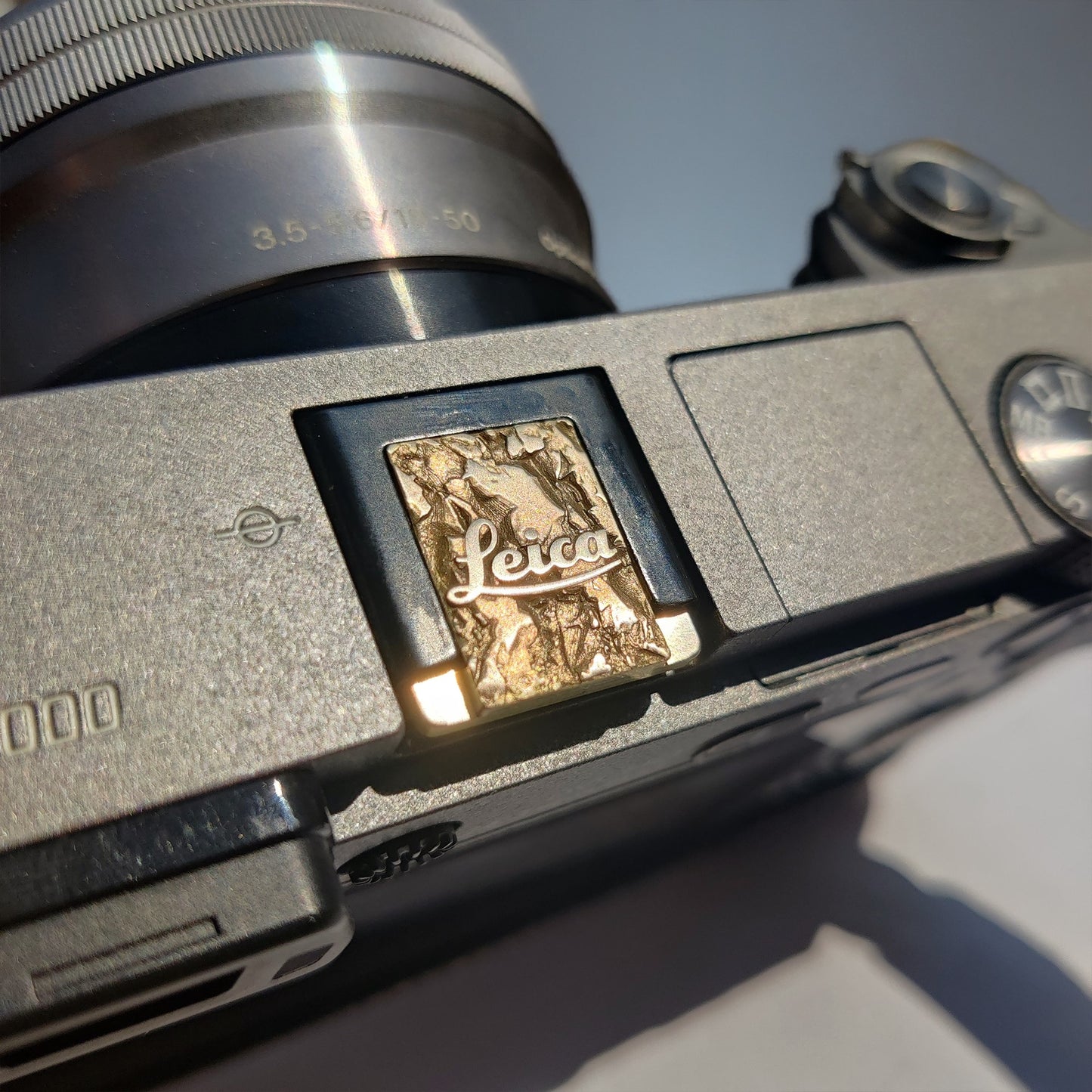 close-up of gold brass Leica camera hot shoe cover
