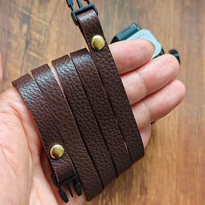 Brown leather camera strap on hand