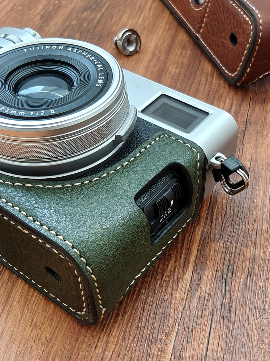 Fujifilm X100vi camera with a green leather case on a wooden surface