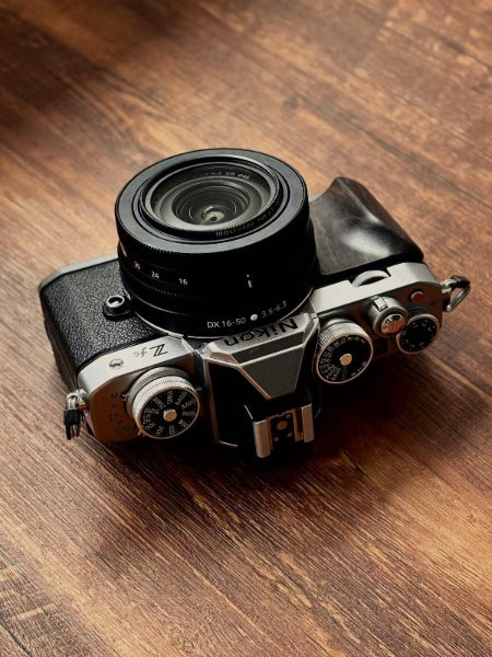 Nikon zfc camera with dark wood grip on a wooden surface