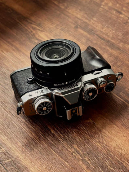 Nikon zfc camera with dark wood grip on a wooden surface