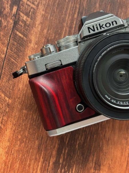 Nikon zfc camera with a red wood grip on a wooden surface
