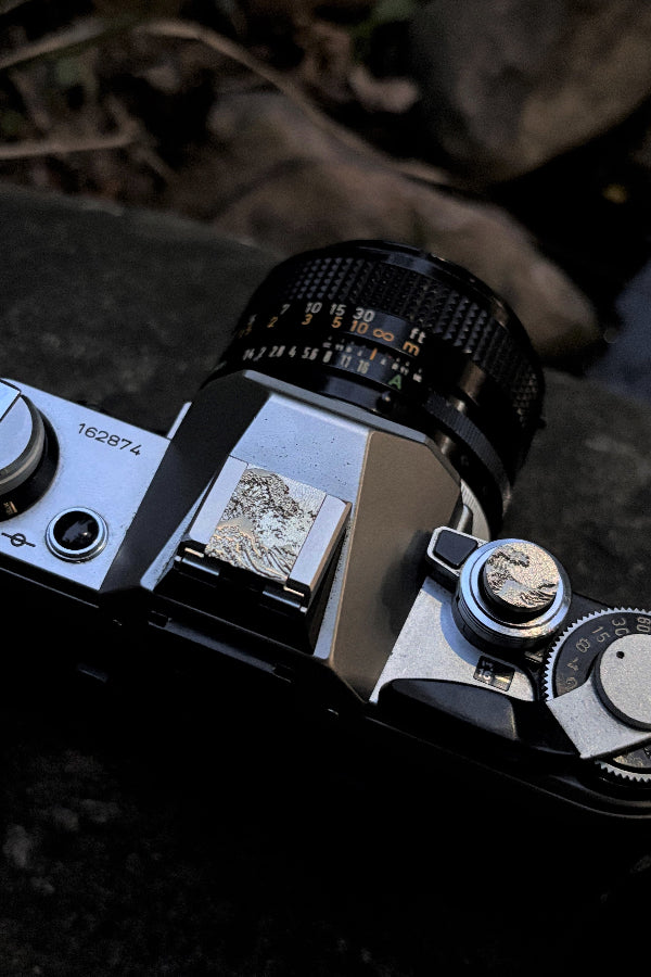 Close-up of a vintage camera sea wave hot shoe cover and shutter button