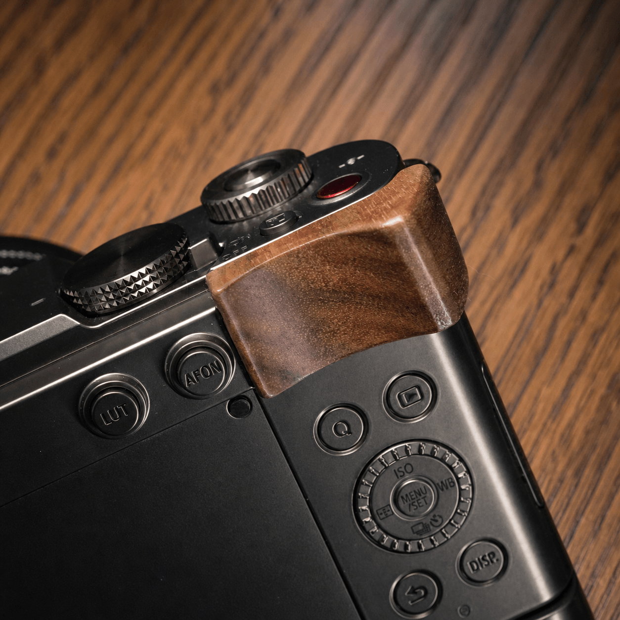Close-up of the top corner of a black Panasonic S9 camera body with a brown wooden grip cover.