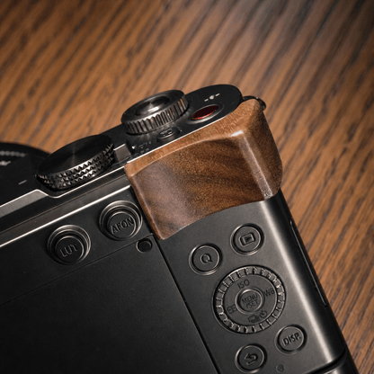Close-up of the top corner of a black Panasonic S9 camera body with a brown wooden grip cover.