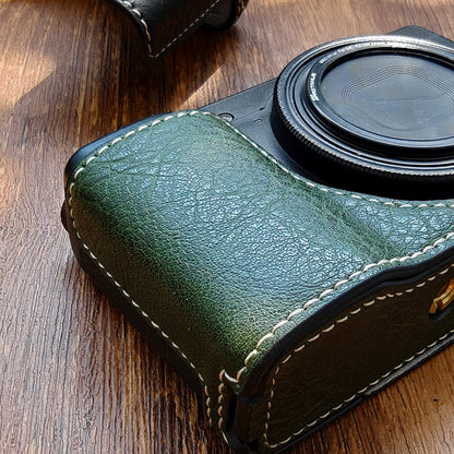 Green leather camera case on Ricoh GR3 camera on a wooden surface
