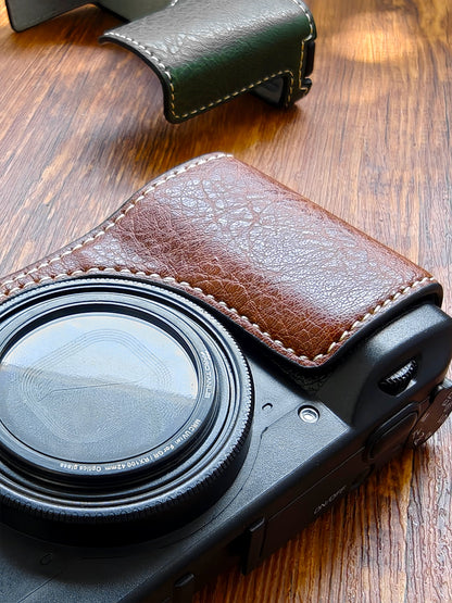 Ricoh GR3 camera with a brown leather case on a wooden surface