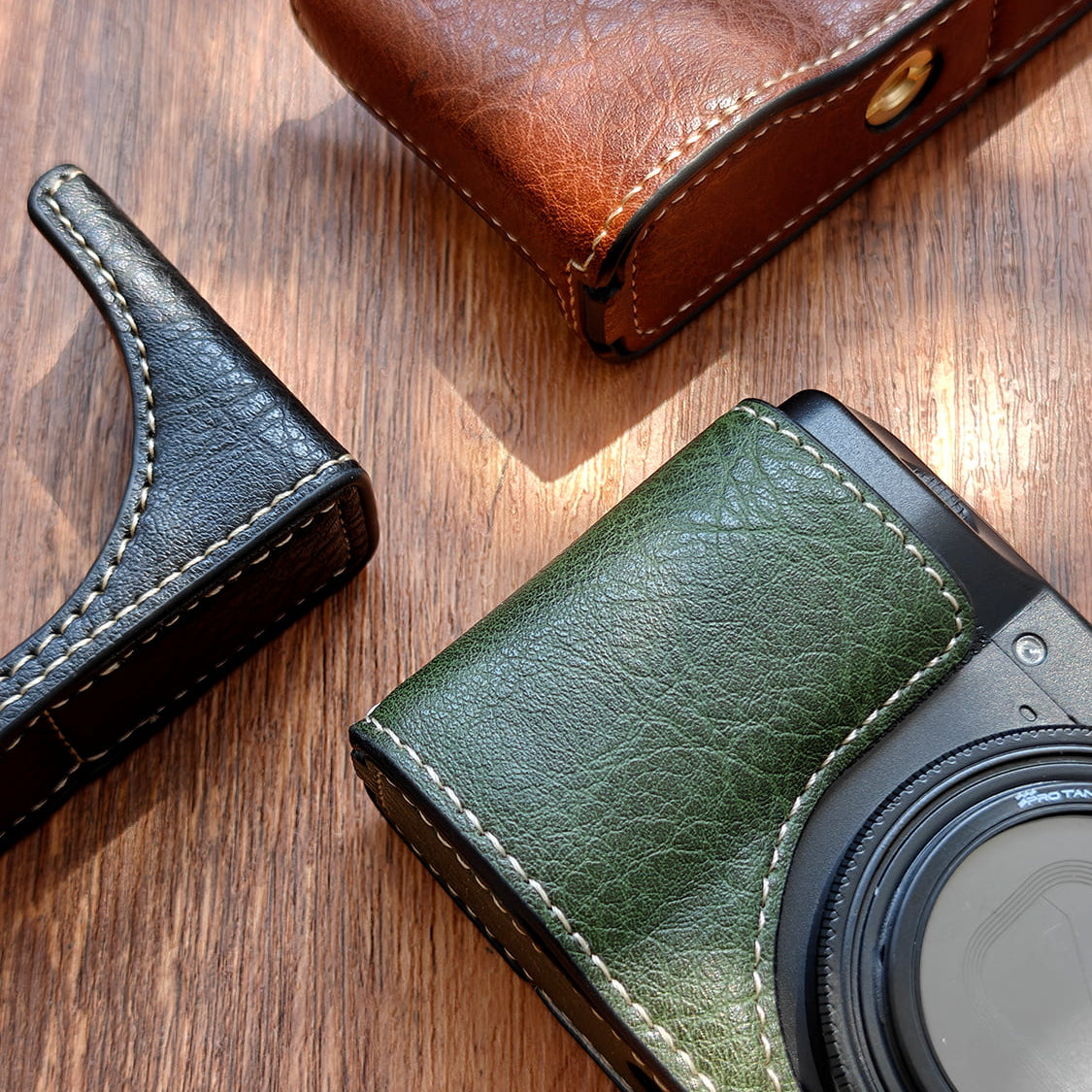 Green leather Ricoh GR3 camera case on a wooden surface