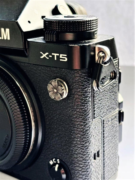 Close-up of a sakura design flash remote pc sync terminal cap cover on a black Fujifilm X-T5 camera