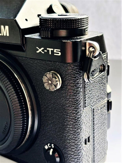 Close-up of a sakura design flash remote pc sync terminal cap cover on a black Fujifilm X-T5 camera