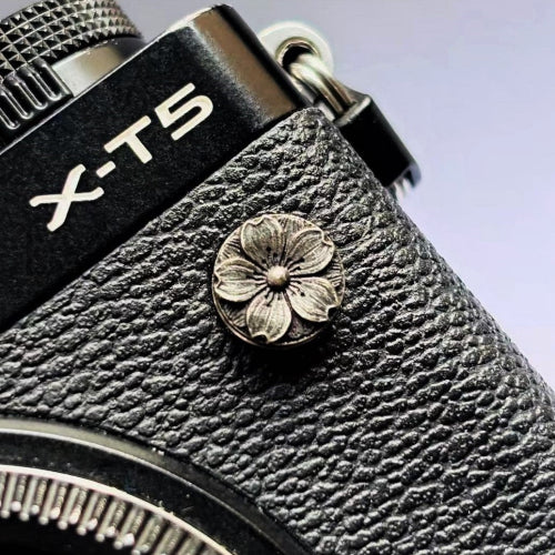 Close-up of a sakura design flash remote pc sync terminal cap cover on a black Fujifilm X camera